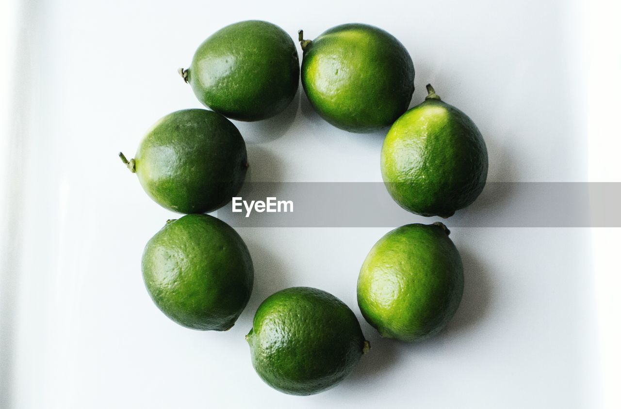 Directly above shot of green limes on white background