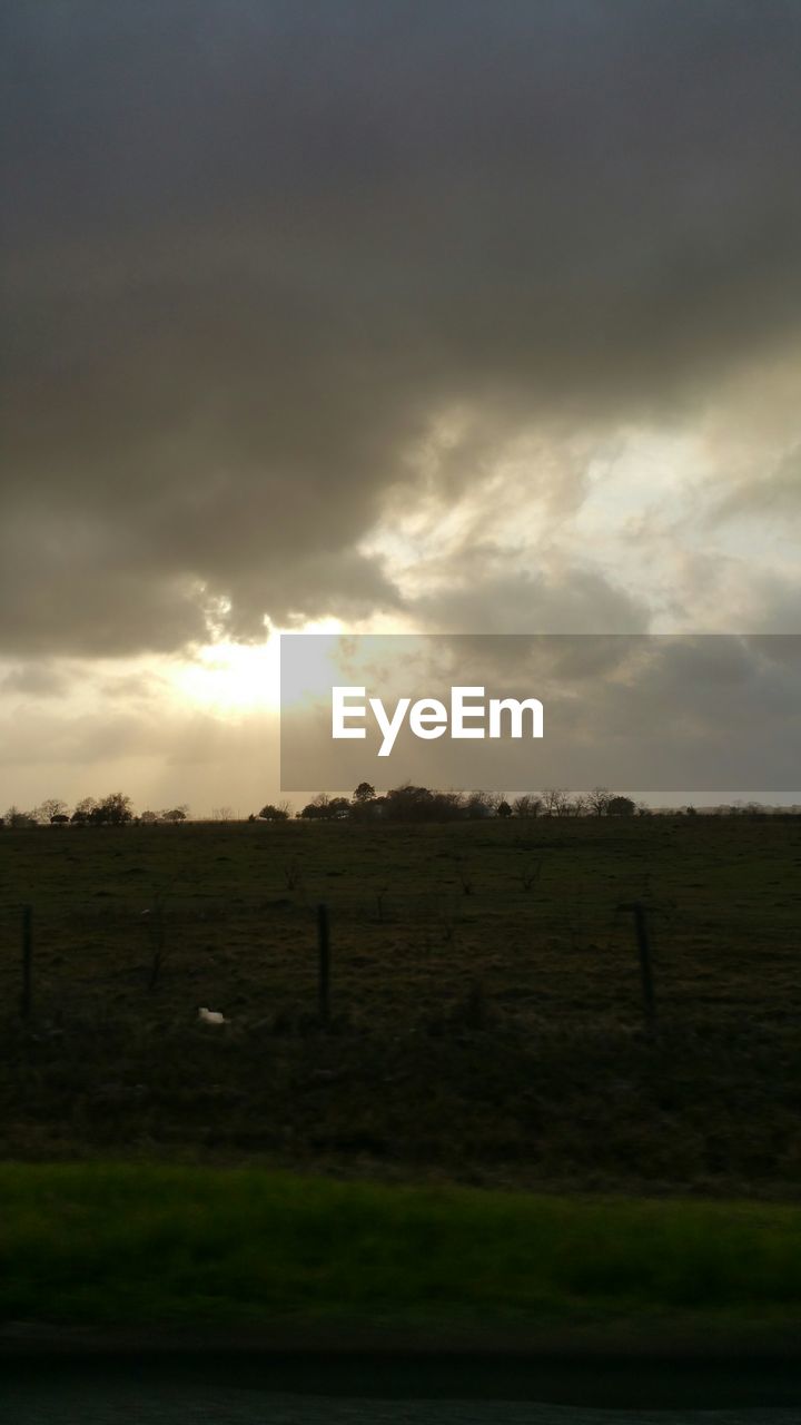 Scenic view of field against cloudy sky