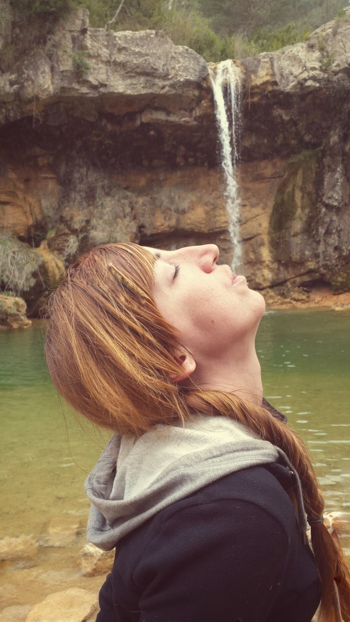 Woman relaxing by waterfall