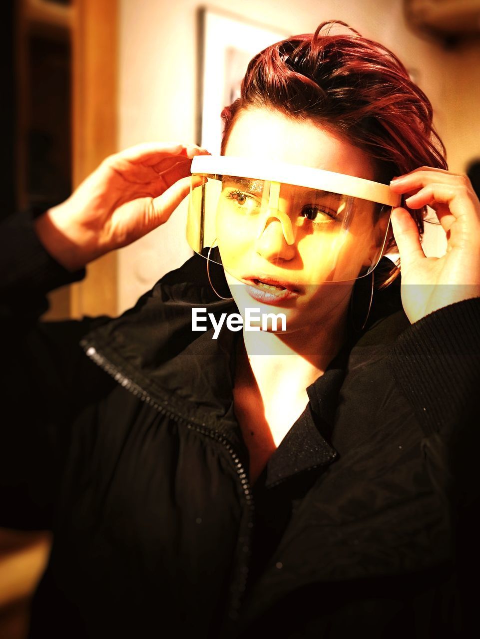 PORTRAIT OF A YOUNG WOMAN HOLDING EYEGLASSES WITH MASK