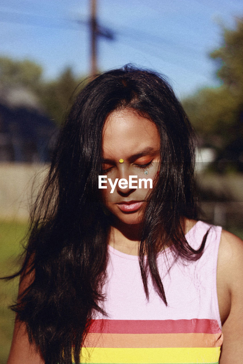 Teenage girl with eyes closed standing outdoors