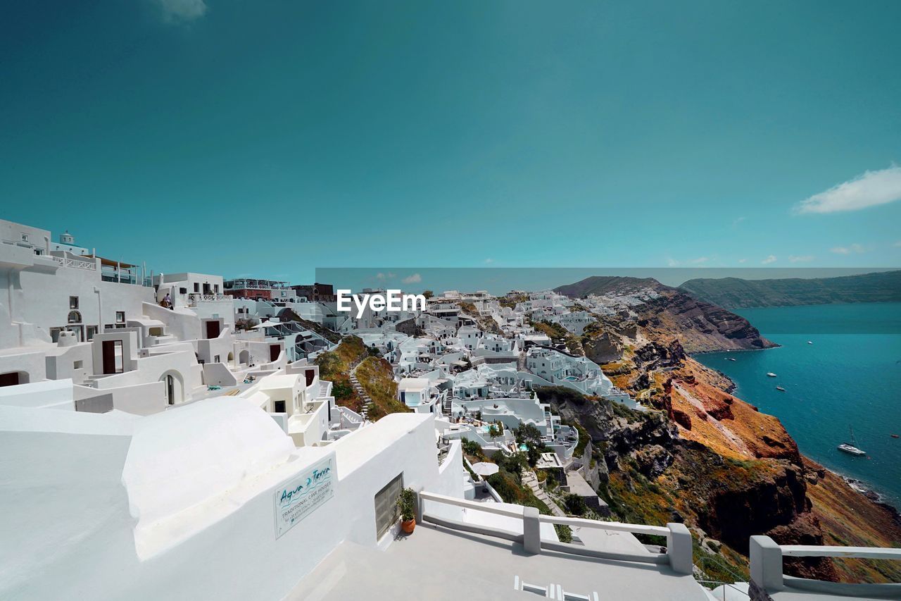 High angle view of townscape by sea against sky