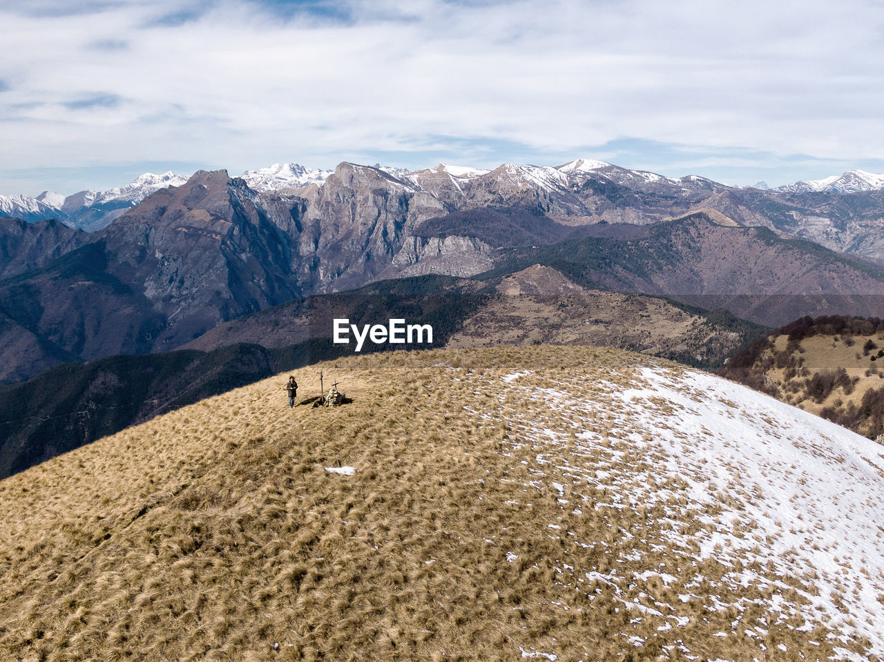 High angle view of man on grass against mountains and sky