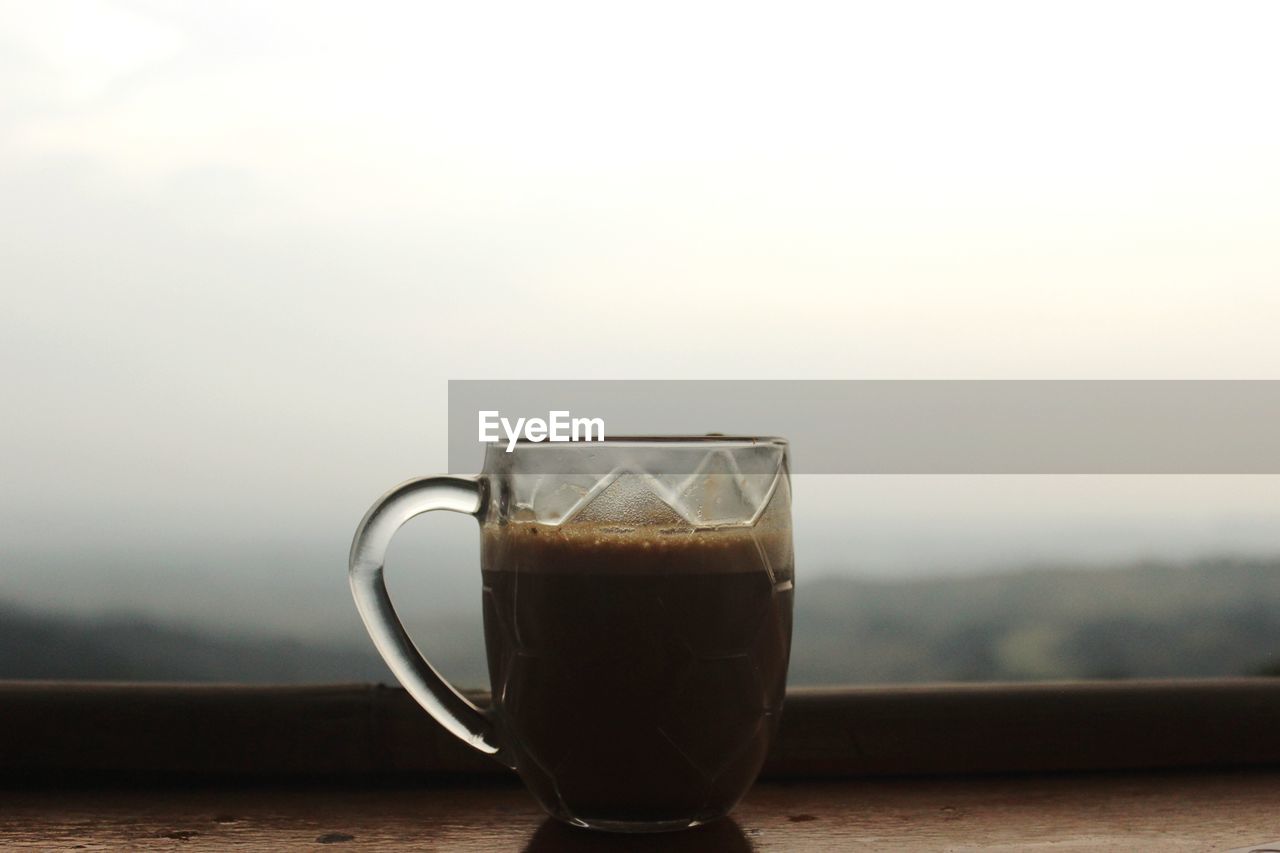 Close-up of coffee in cup on table against sky