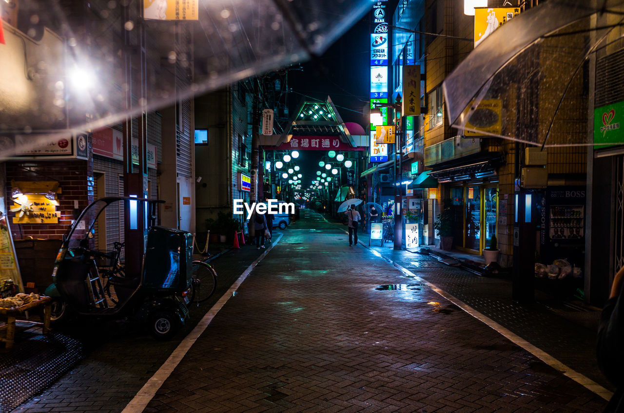 People walking on illuminated city at night