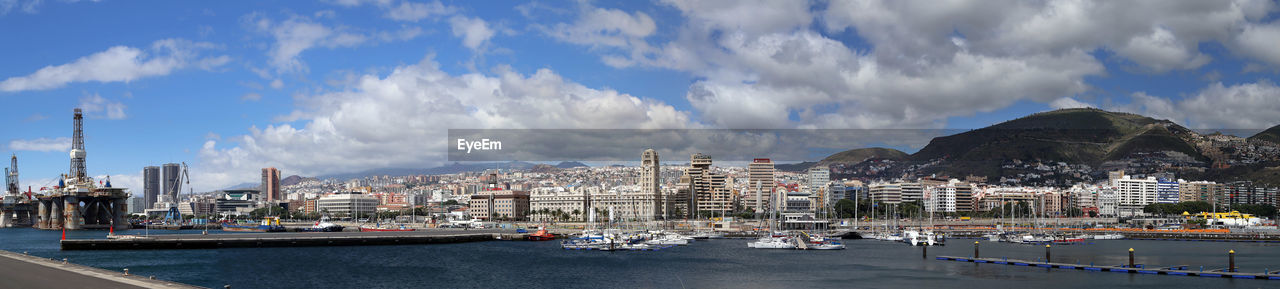 Panoramic view of city against cloudy sky