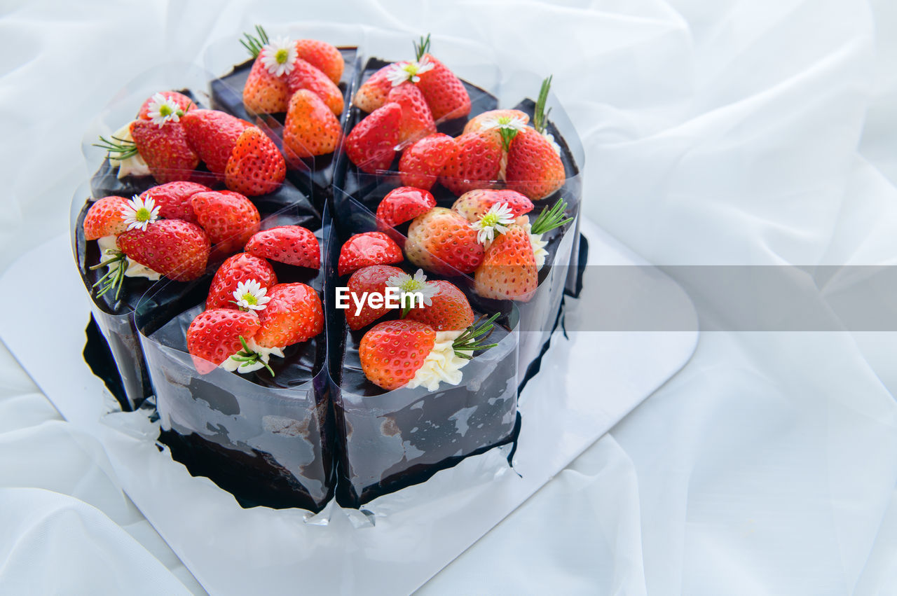 Chocolate cake decorated with fresh strawberry on white cloth, cake and bakery concept