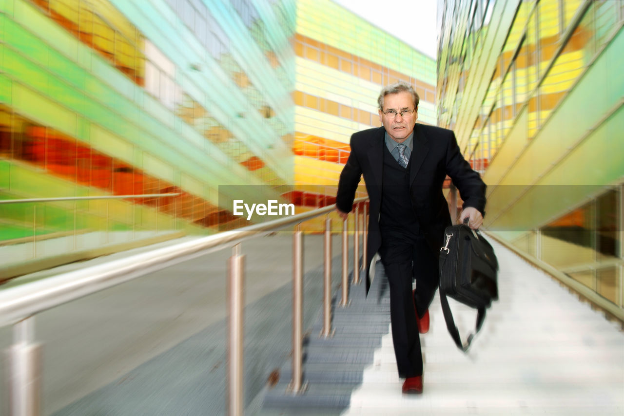 Portrait of businessman walking on steps