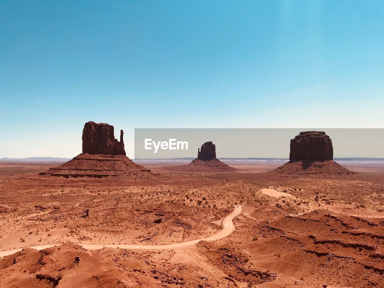 Rock formations on landscape against clear blue sky