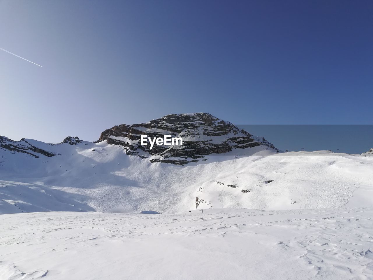 Scenic view of snowcapped mountain against clear blue sky