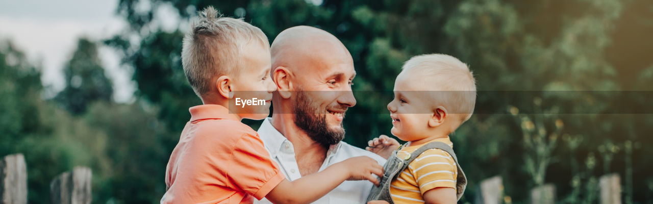 Smiling father and son looking at boy