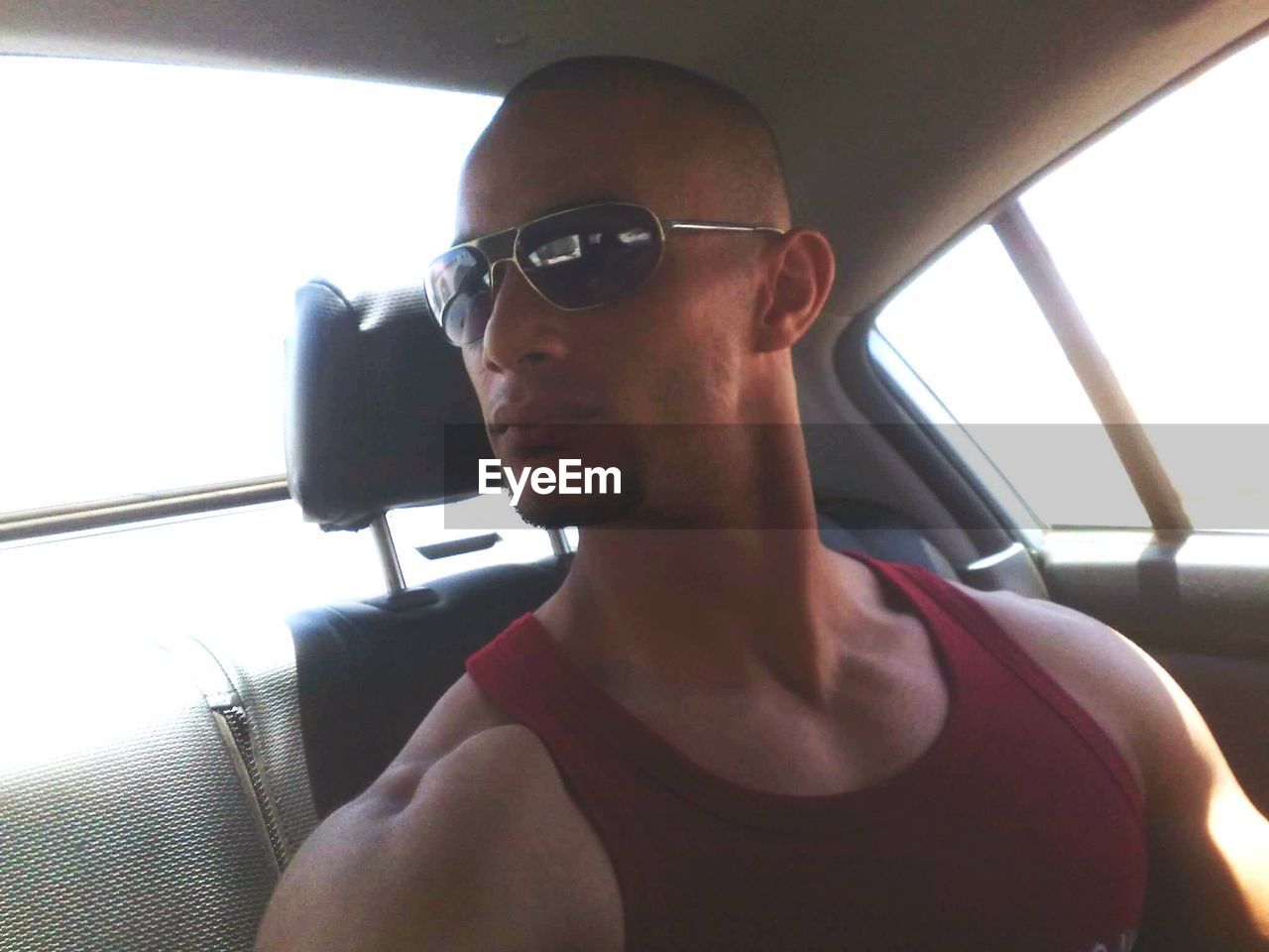 Young man wearing sunglasses while traveling in car