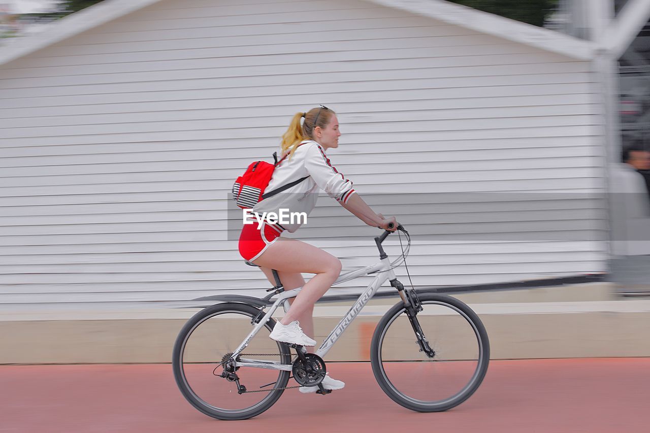 SIDE VIEW OF WOMAN BICYCLING ON BICYCLE