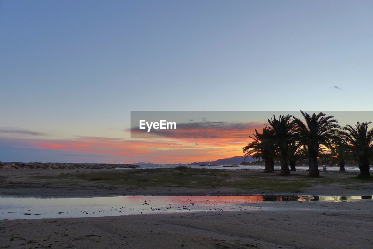 SCENIC VIEW OF BEACH AT SUNSET