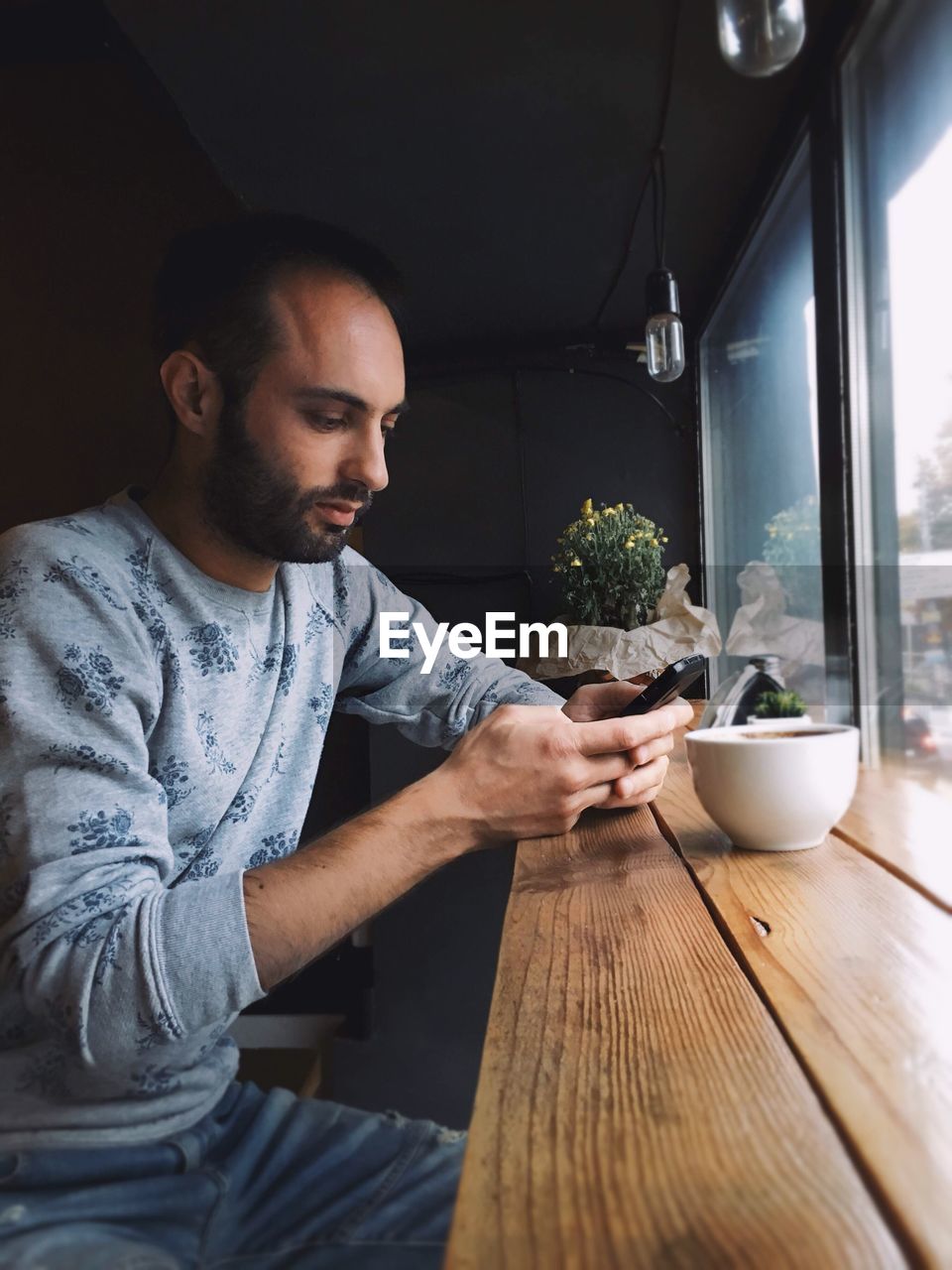 Man using smart phone at cafe