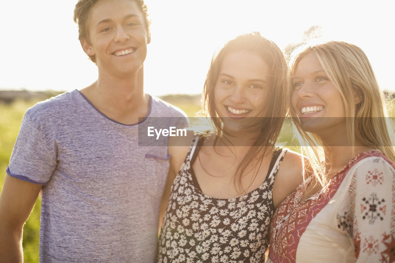 Portrait of happy woman standing with friends outdoors