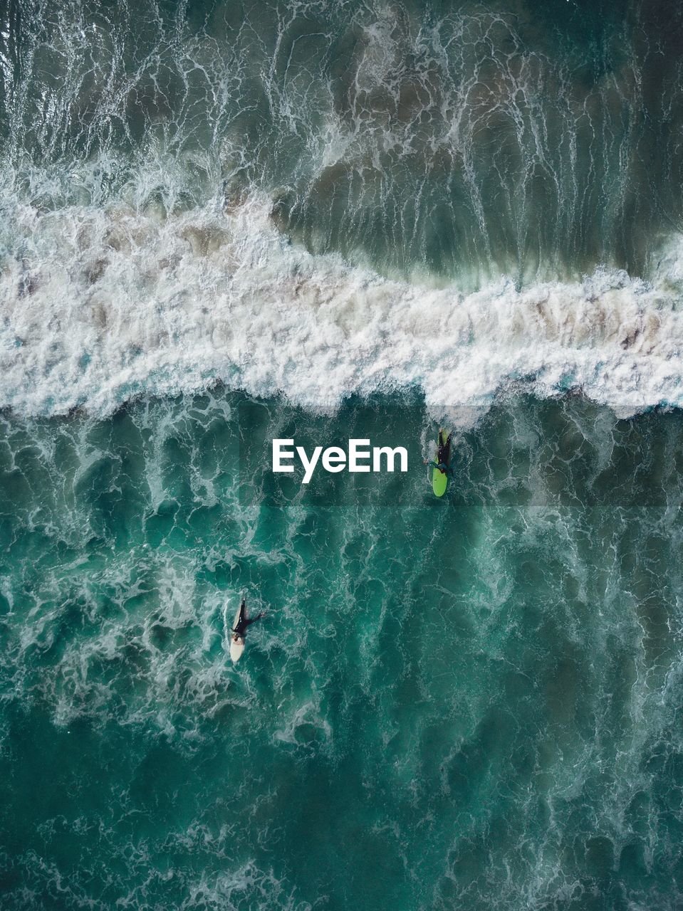 Aerial view of men surfing on sea