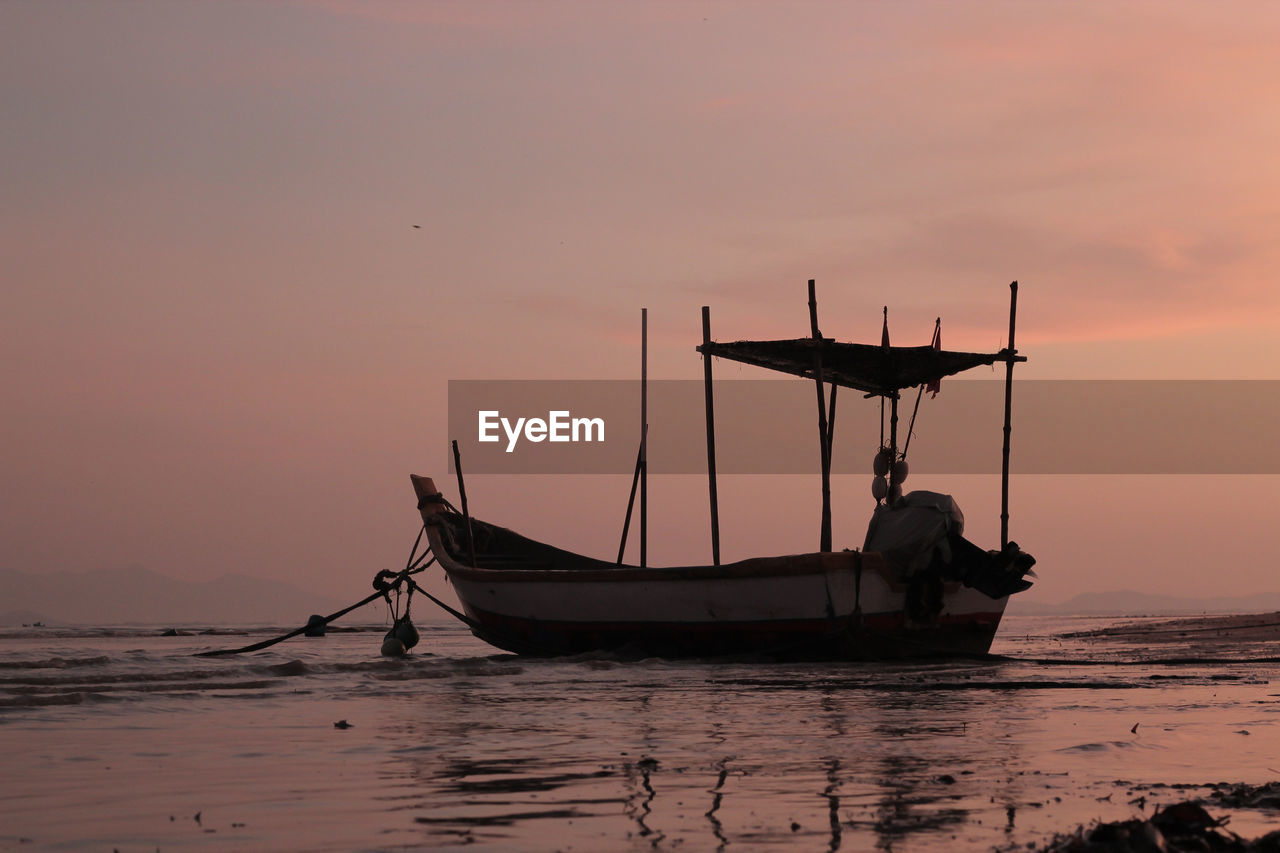 FISHING BOAT IN SEA AT SUNSET