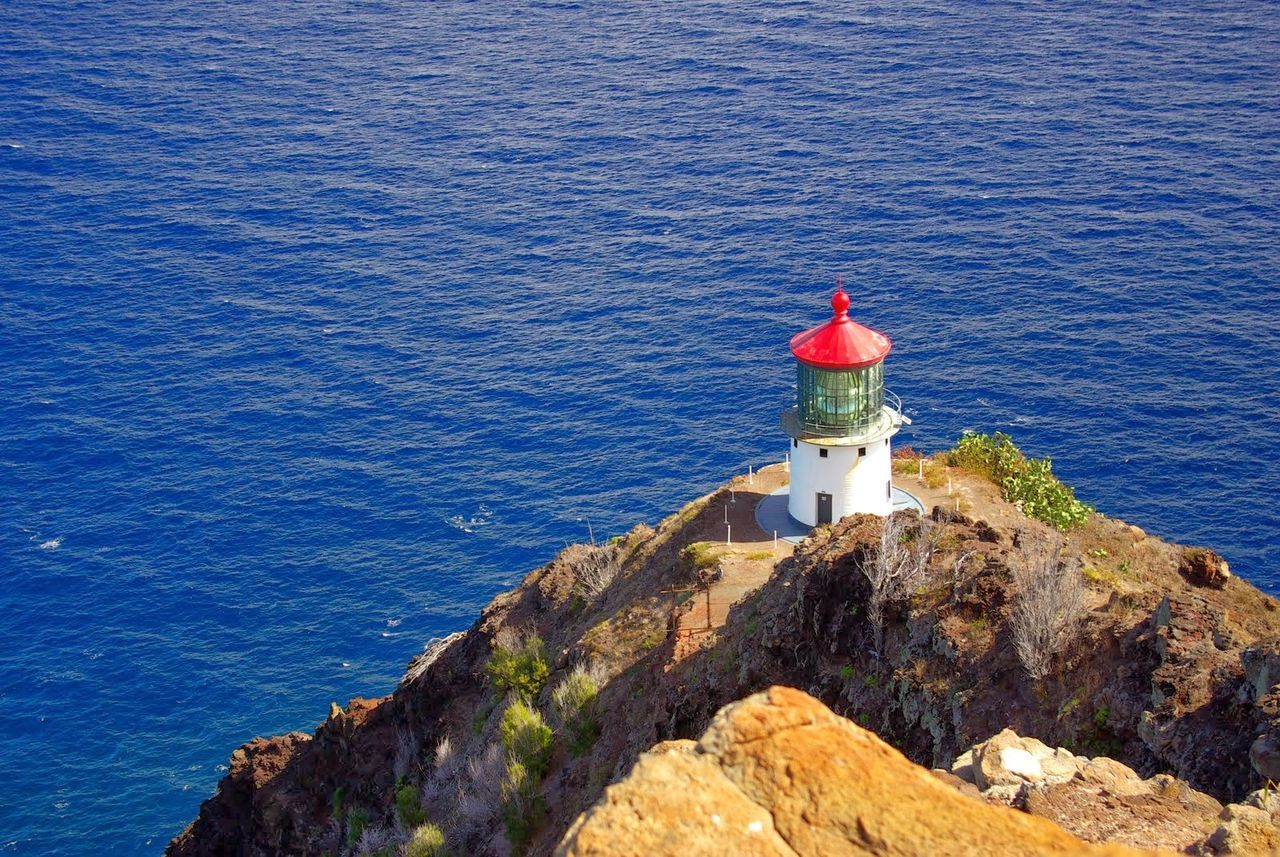 Lighthouse on cliff by sea