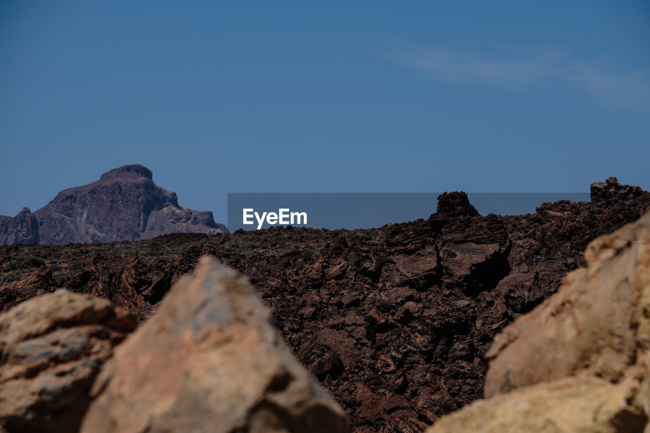 LOW ANGLE VIEW OF ROCK FORMATION AGAINST CLEAR SKY