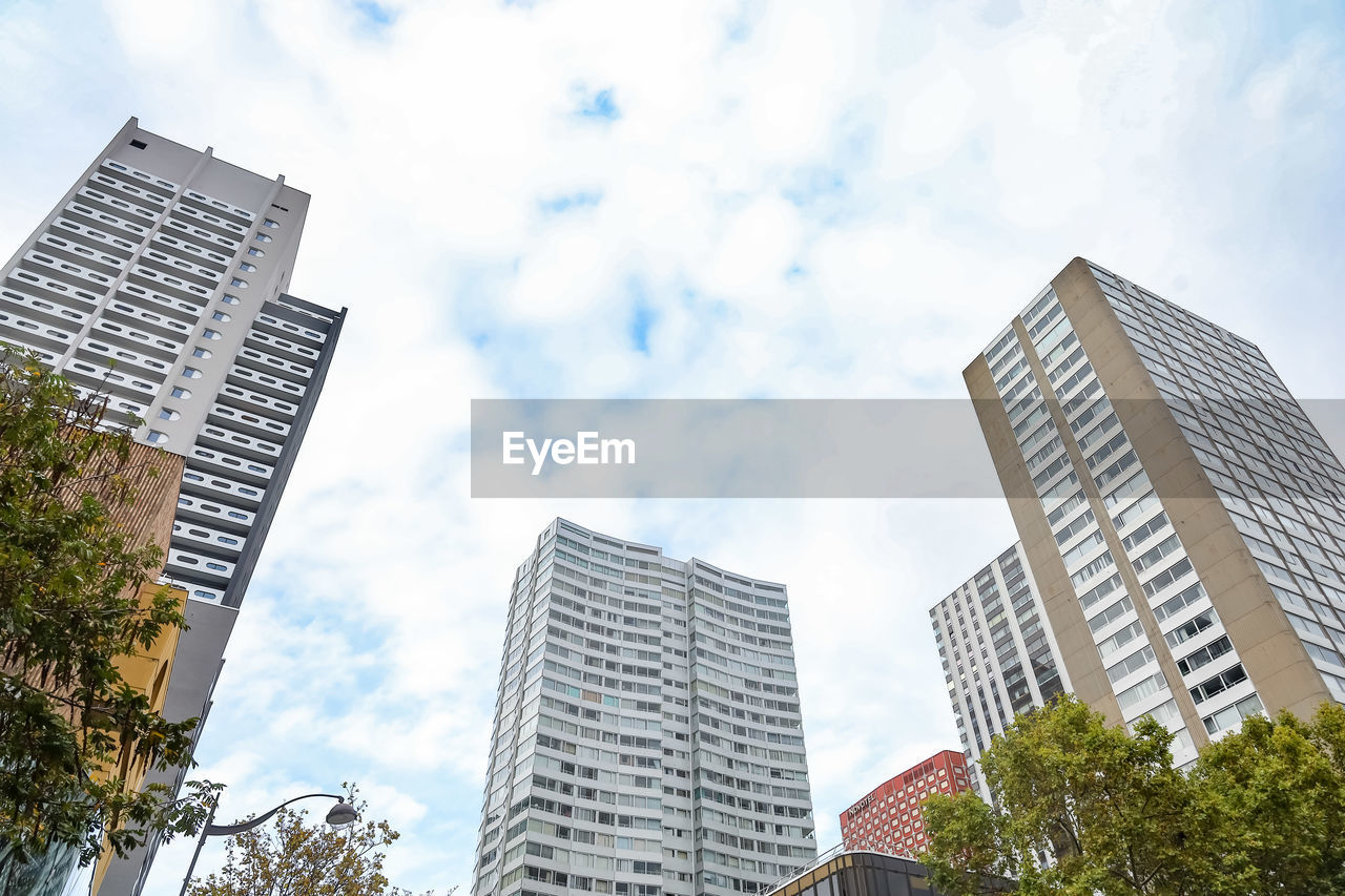 Low angle view of modern buildings against sky in paris, france 