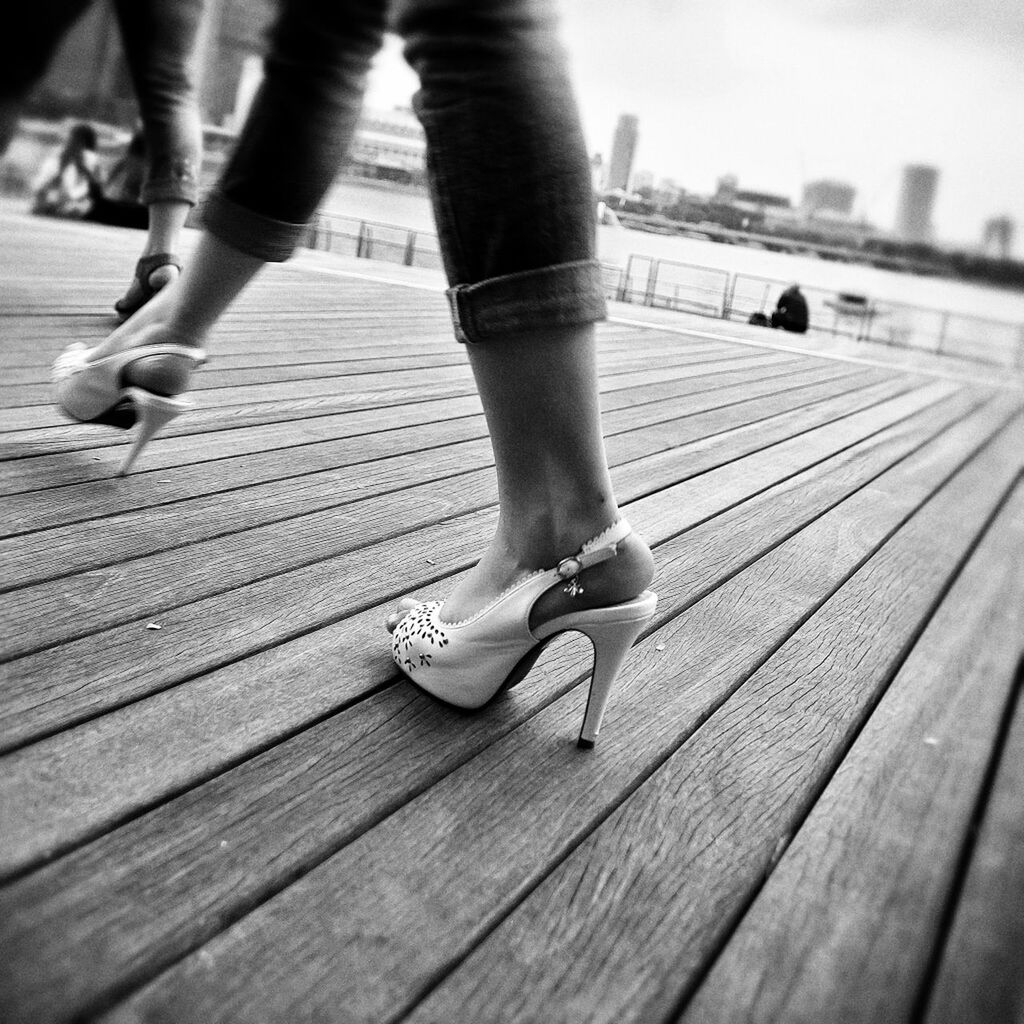 Low section of women walking on boardwalk