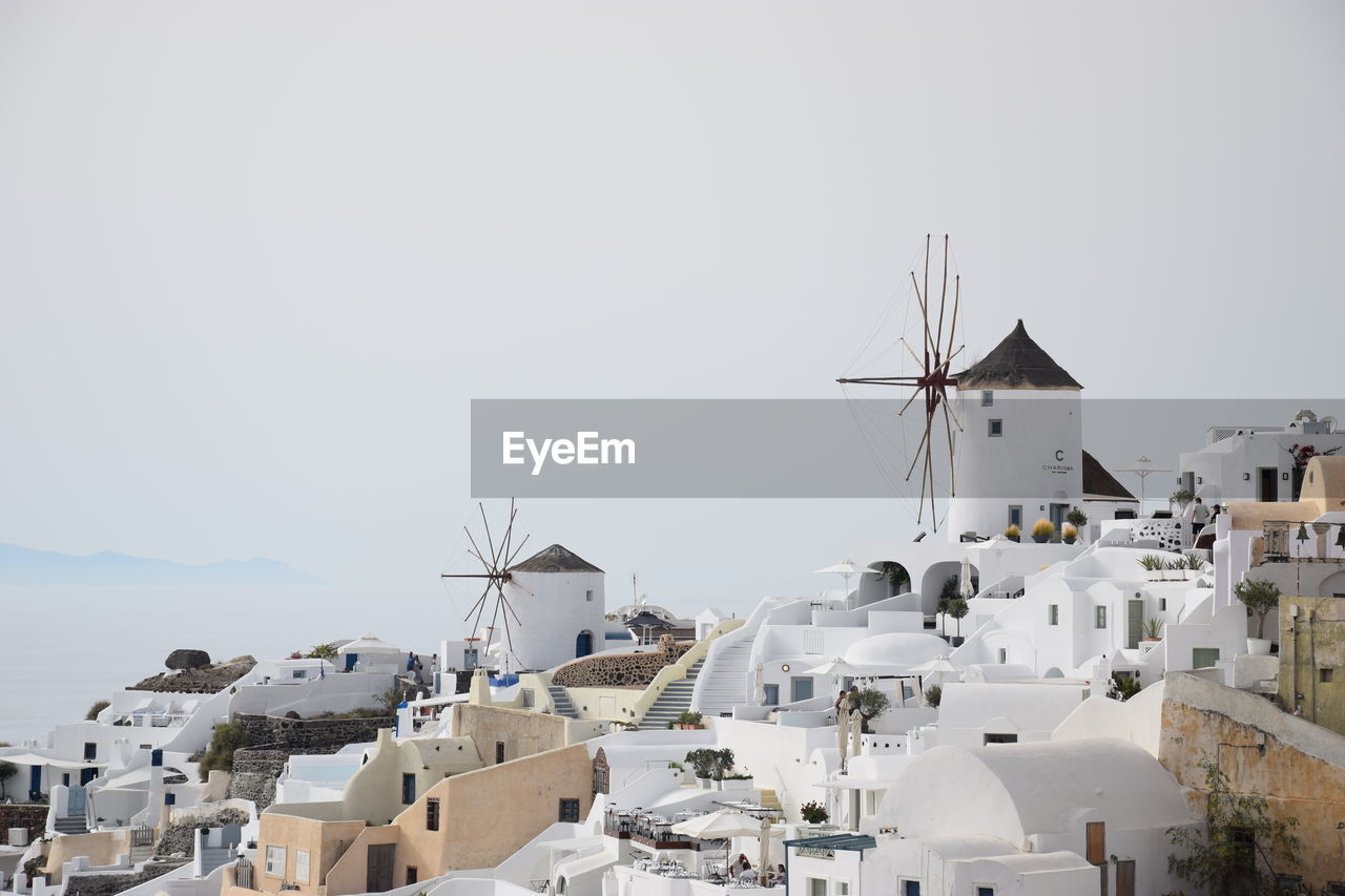 TRADITIONAL WINDMILL BY BUILDING AGAINST CLEAR SKY