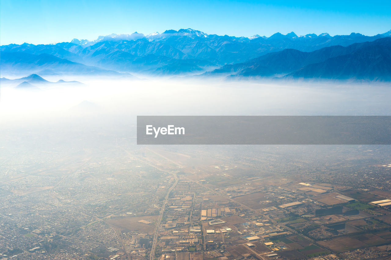 Aerial view of santiago de chile under a layer of smog with the andes mountain range in the back