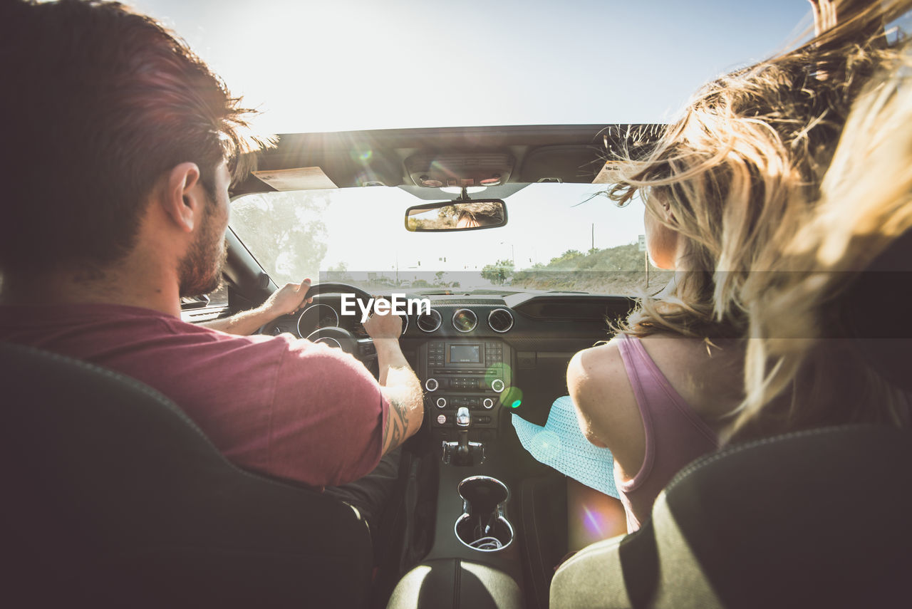 Rear view of couple sitting in car