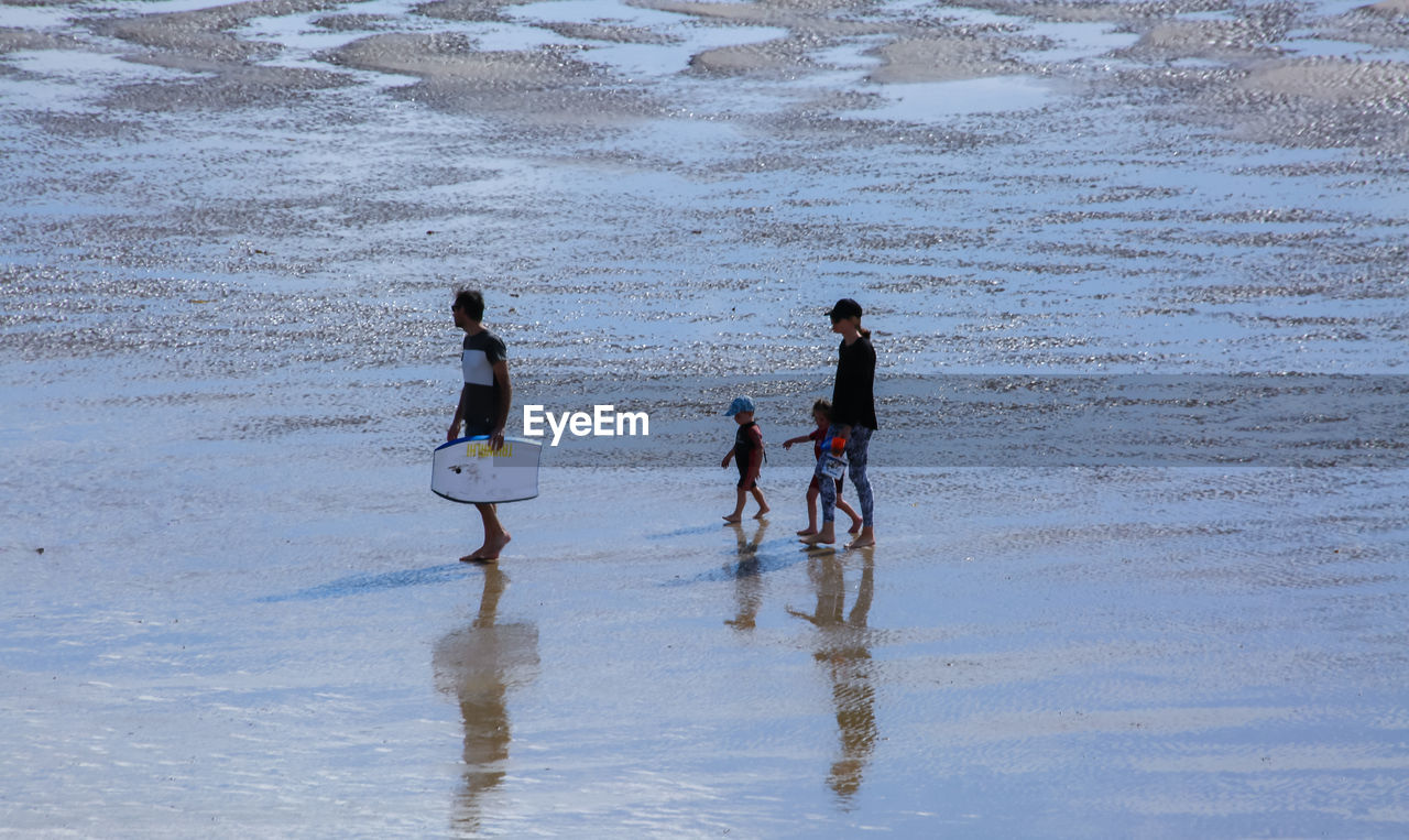 REAR VIEW OF PEOPLE ON BEACH