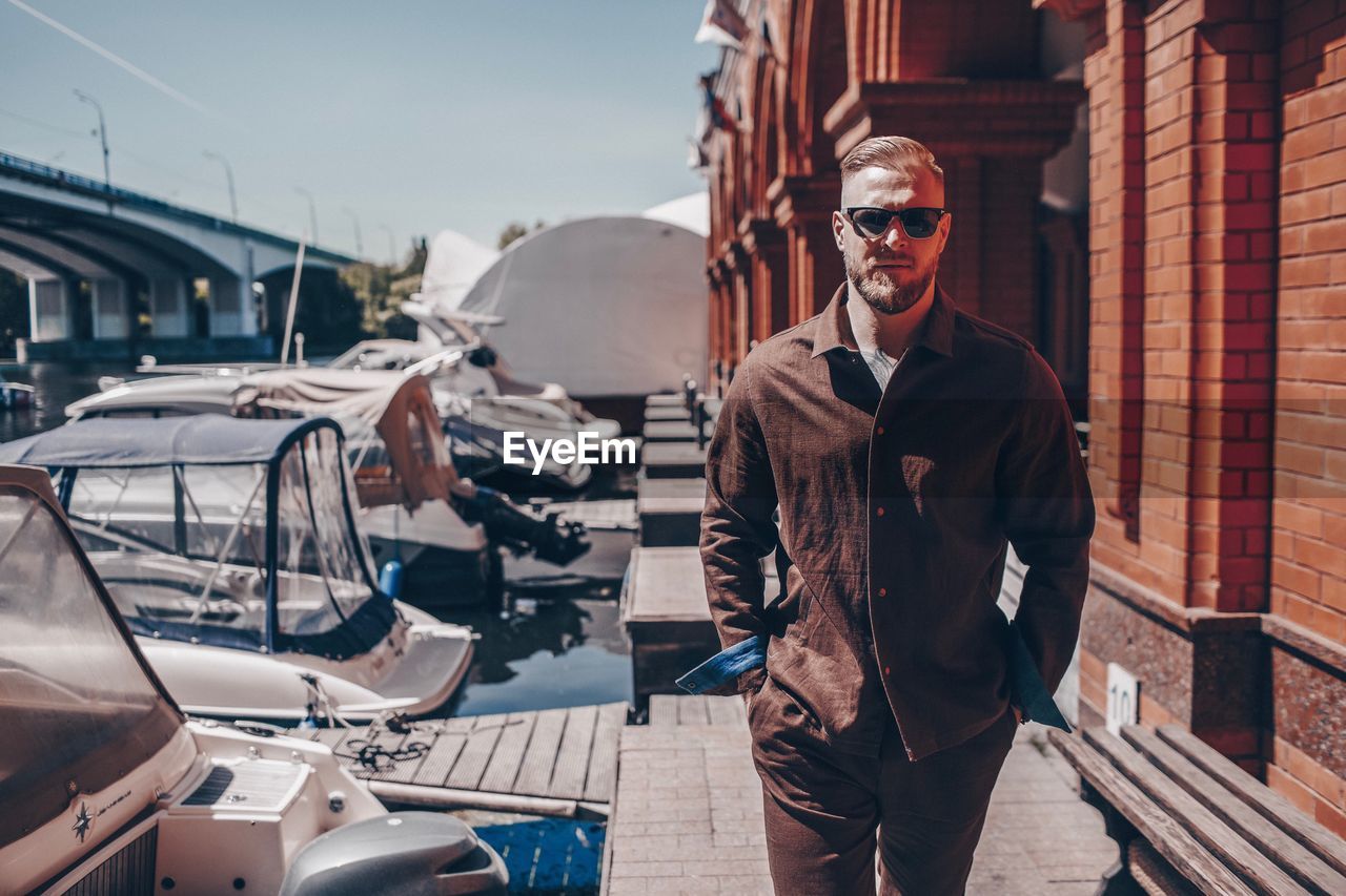 Portrait of man wearing sunglasses while walking in city