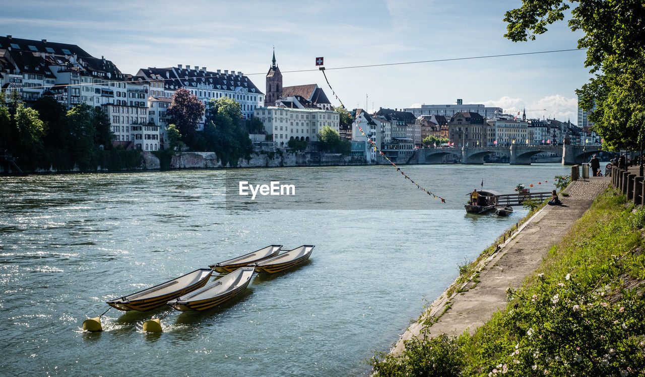 BOATS IN RIVER AGAINST CITY