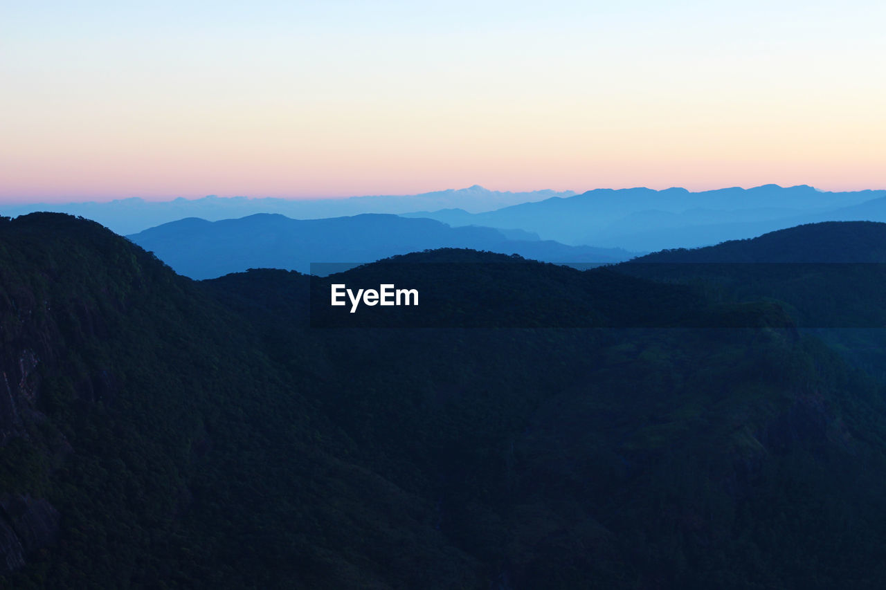 Scenic view of silhouette mountains against sky at sunset