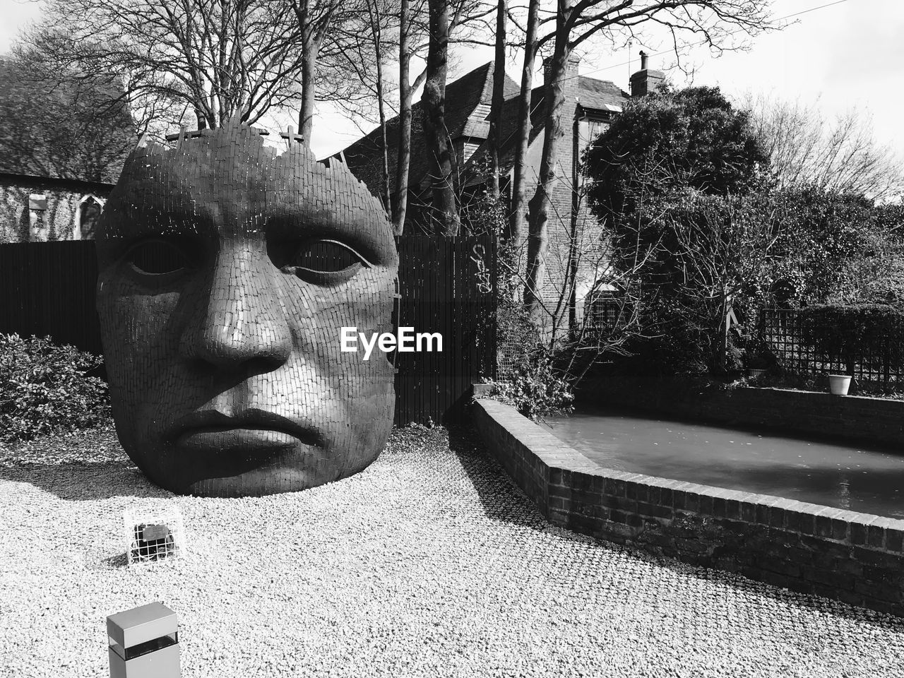 CLOSE-UP OF STATUE AGAINST TREES AND PLANTS