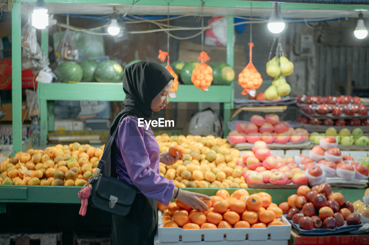 Rear view of fruits for sale at market stall