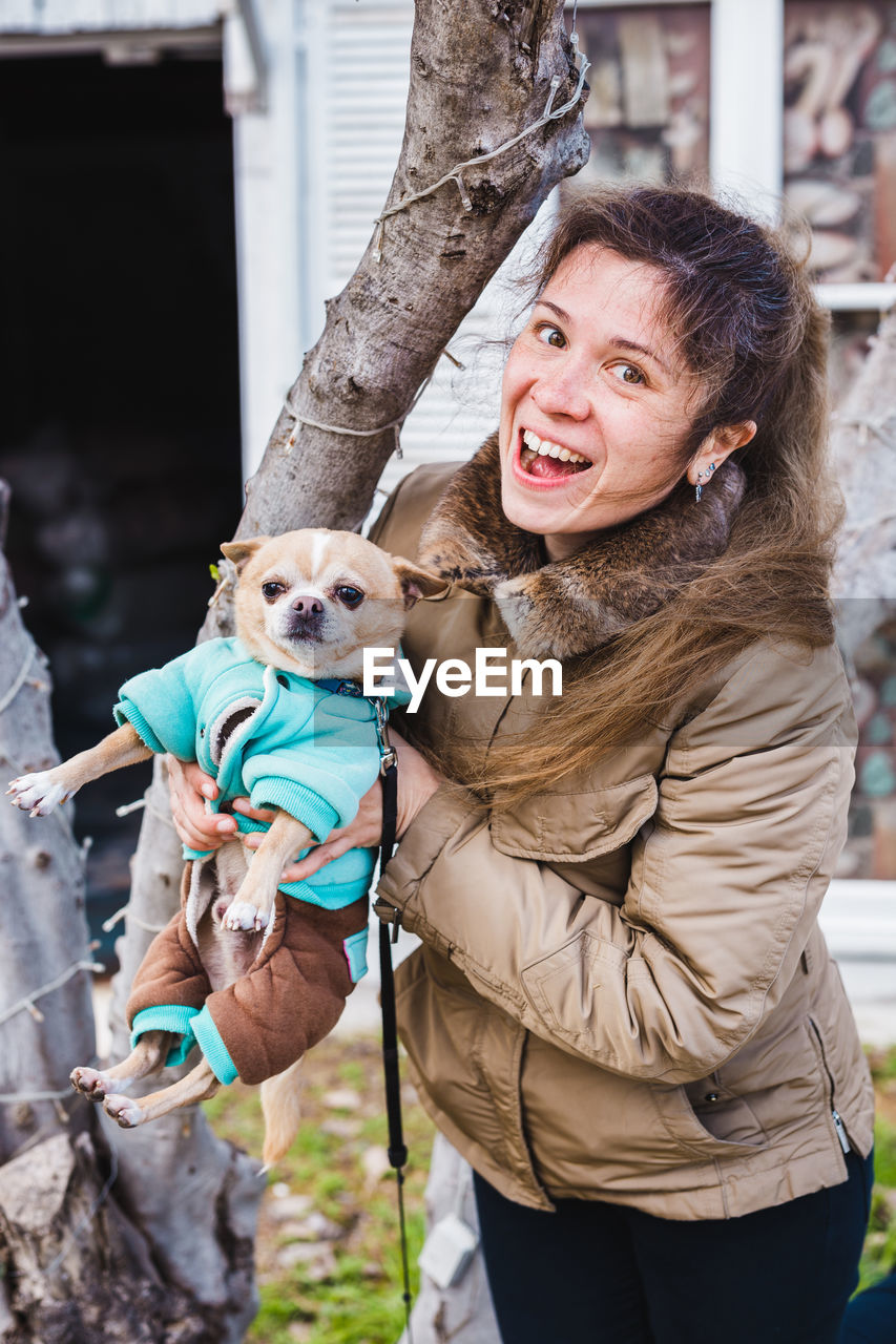 PORTRAIT OF WOMAN WITH DOG ON THE BACKGROUND