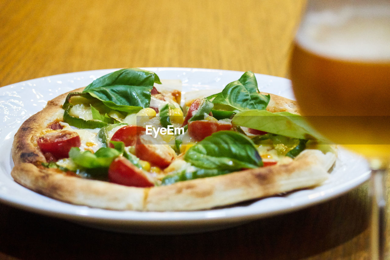 Close-up of homemade pizza served on table with glass