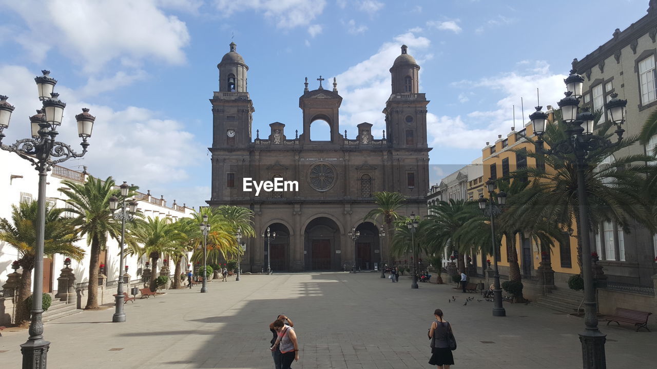 People at las palmas cathedral against sky