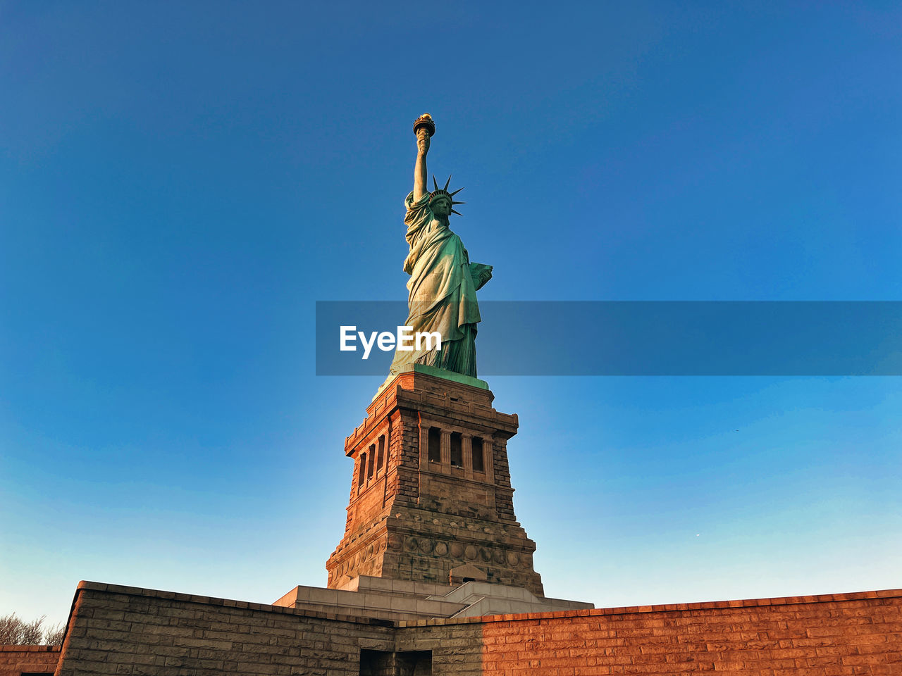 low angle view of statue of liberty against clear blue sky