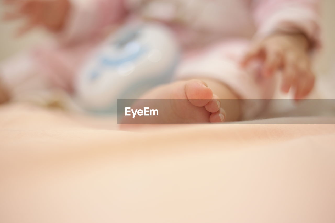 Low section of baby on bed