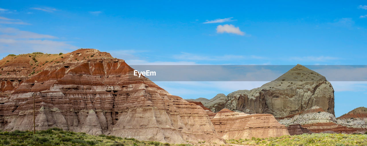 Rock formations on landscape against cloudy sky