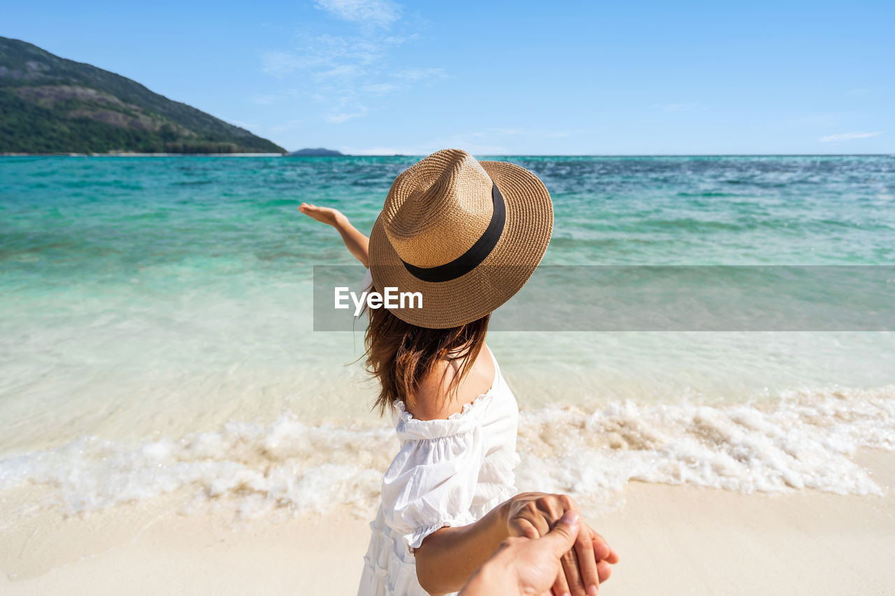 WOMAN WEARING HAT ON BEACH