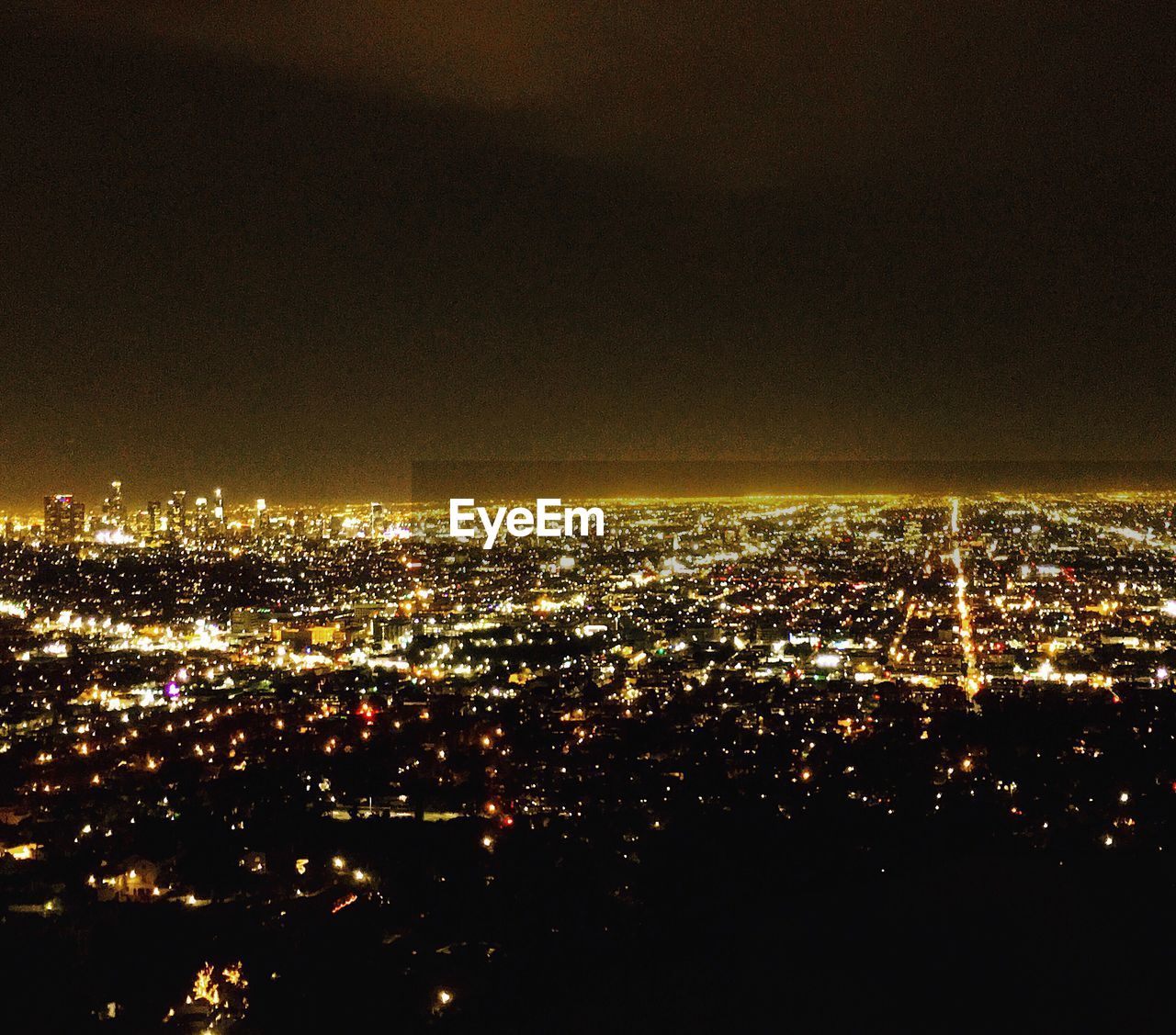 AERIAL VIEW OF ILLUMINATED CITYSCAPE AT NIGHT