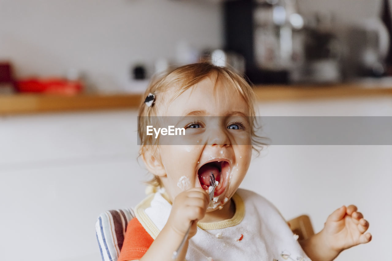 Smiling girl eating food at home