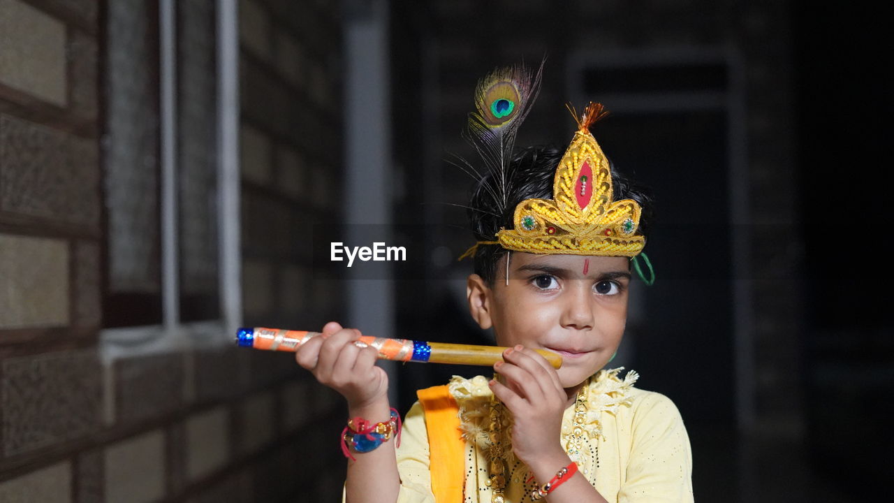 Asian boy posing as shri krishna or kanhaiya on fancy dress or gokulashtami festival.