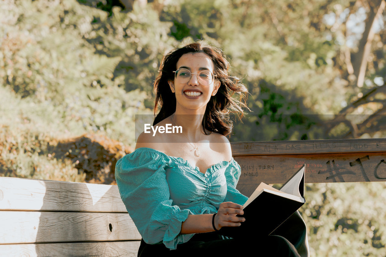 Portrait of smiling young woman sitting outdoors