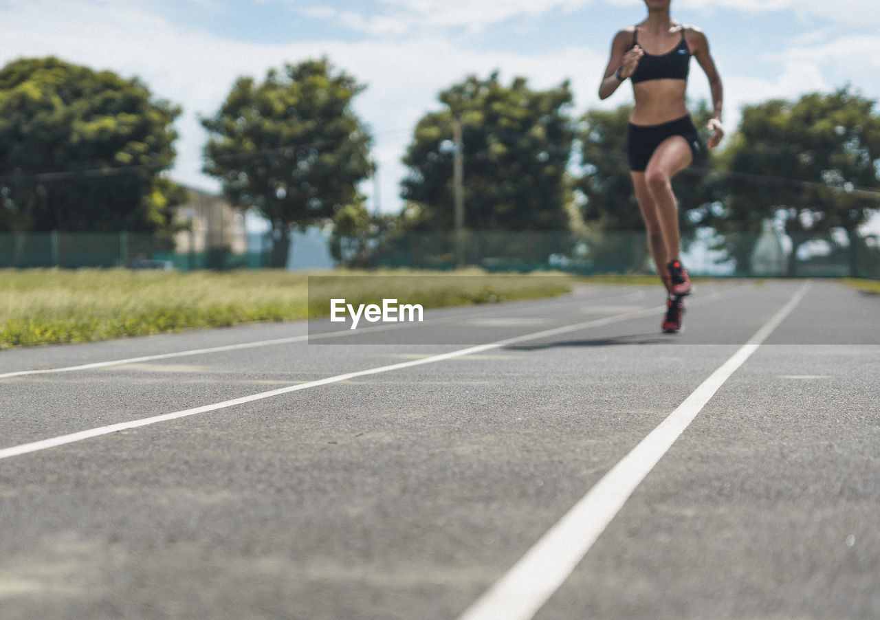 Low section of woman running on road