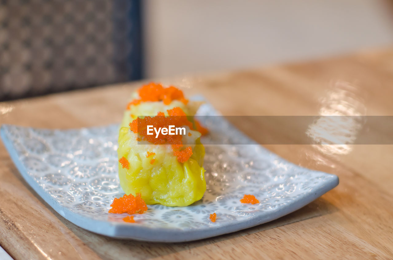 CLOSE-UP OF ICE CREAM ON TABLE