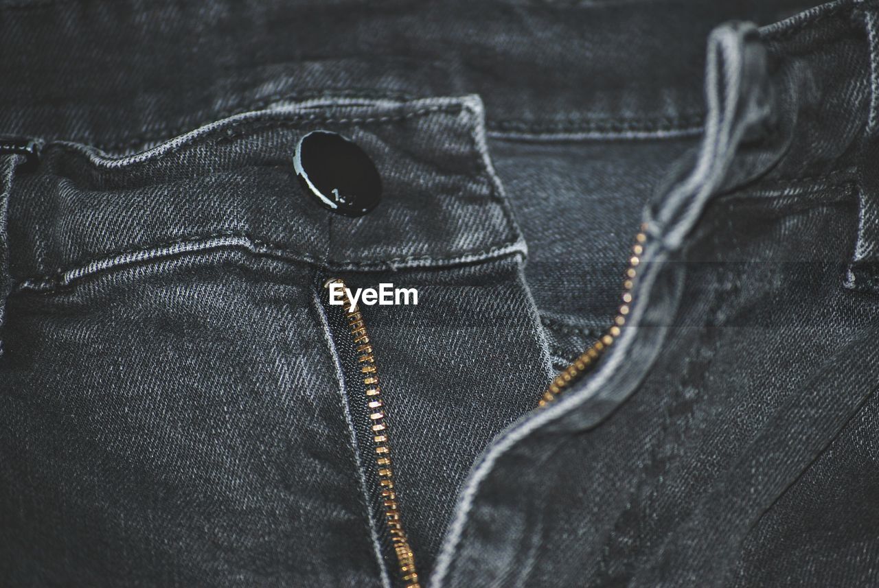 Full frame shot of gray jeans with open zipper