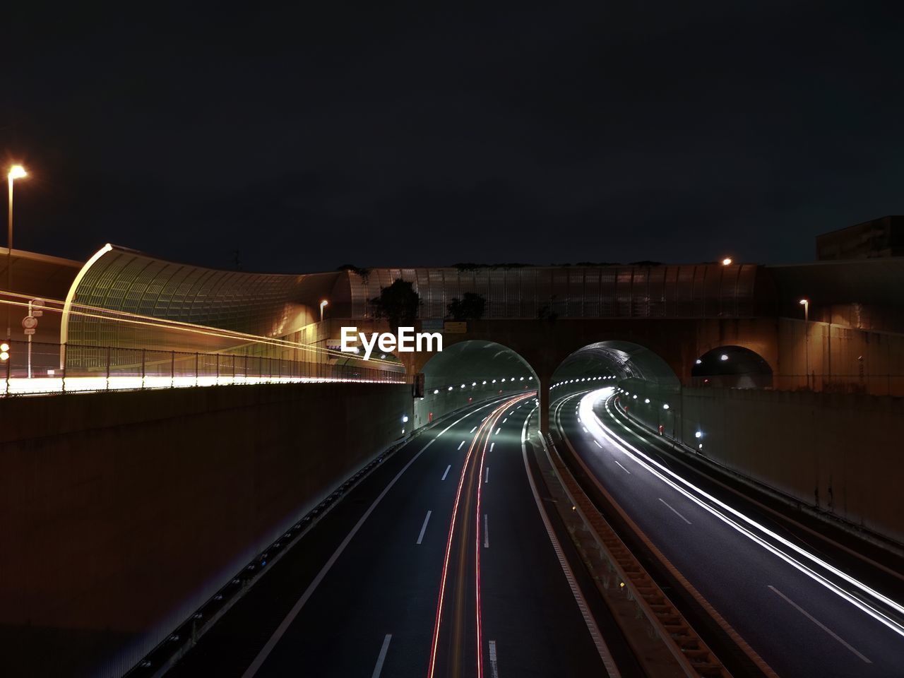 night, light trail, illuminated, transportation, long exposure, motion, architecture, speed, city, darkness, light, built structure, road, blurred motion, bridge, mode of transportation, traffic, street, tail light, highway, building exterior, street light, no people, evening, headlight, city life, sky, overpass, travel, travel destinations, nature, on the move, infrastructure, motor vehicle, lighting equipment, outdoors, the way forward, car, light - natural phenomenon, vehicle light, cityscape